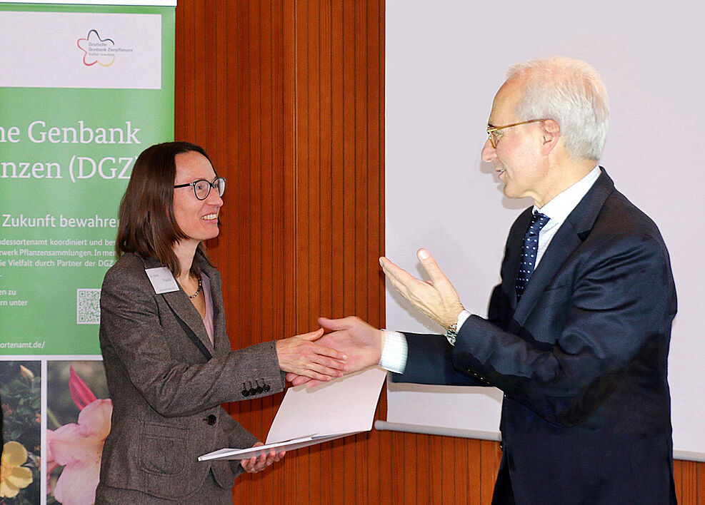 
	Dr. Sylvia Plaschil (JKI) erhält vom Präsidenten des Bundessortenamts, Udo von Kröcher, Partnerschaftsurkunde der Deutschen Genbank Zierpflanzen (© Maryse Huve/Bundessortenamt)
