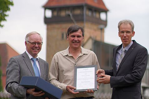 Vor der Kulisse des Geilweilerhofs stehen von links nach rechts: Prof. Dr. Reinhard Töpfer (Leiter der JKI-Rebezüchtung), Preisträger Prof. Dr. Jochen Bogs und Dr. Andreas Kortekamp (2. Vorsitzender Förderer und Freunde des Instituts für Rebenzüchtung)