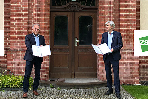 Der Leiter des ZALF Prof. Dr. Frank Ewert (r.) und der Präsident des JKI Prof. Dr. Frank Ordon präsentieren die unterzeichneten Kooperationsverträge vor dem JKI-Eingang in Berlin -Dahlem. © H.Beer/JK