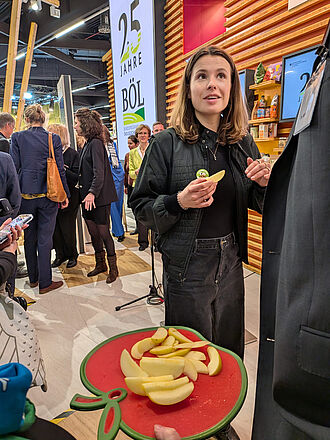 Umweltaktivistin Lisa Neugebauer kostet JKI-Apfelneuzüchtung Pia41 am Stand des BMLEH. © O. Trapp/JKI
