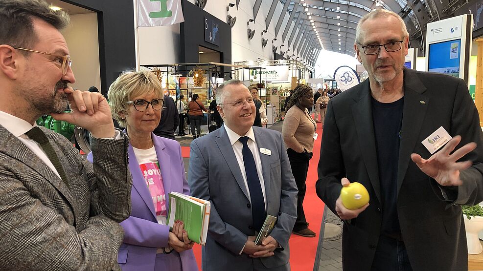 
	Die ZVG-Spitze mit Präsidentin Eva Kähler-Theuerkauf informierte sich bei JKI-Apfelzüchter Dr. Andreas Peil (rechts) am BMEL-Stand auf IPM Essen über Forschung für mehr Nachhaltigkeit im Obstbau.
