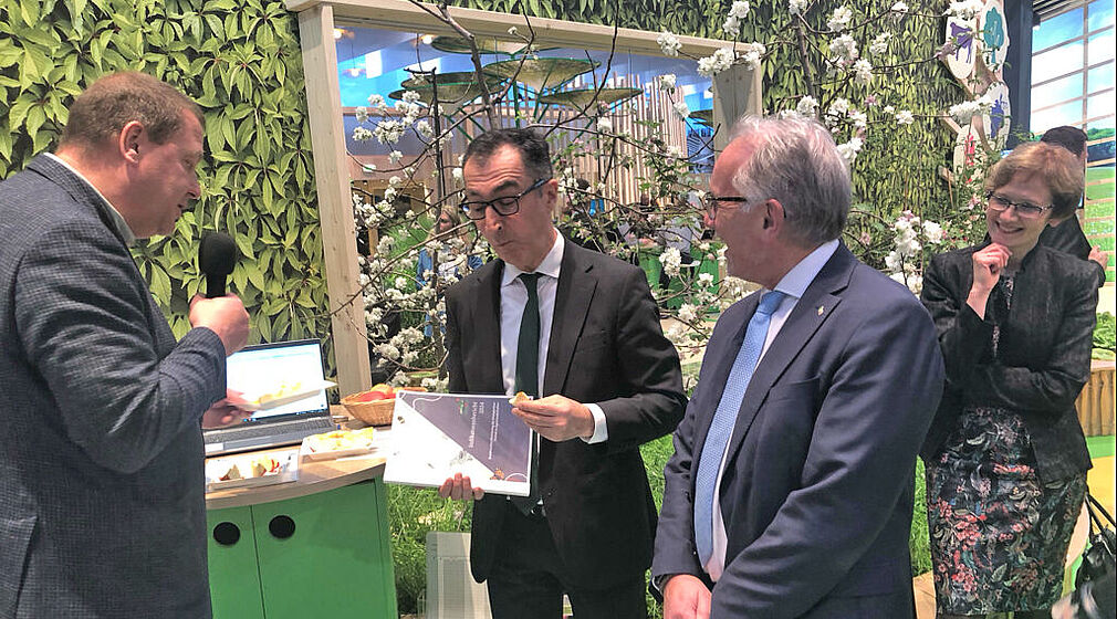 Bundesminister Cem Özdemir und Prof. Dr. Frank Ordon (JKI) zusammen mit Prof. Dr. Henryk Flachowsky (JKI) mit dem MonVia-Indikatorenbericht bei der Apfelverkostung