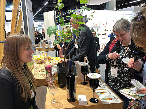 Julia Fuchs vom JKI reicht Besucherinnen eine Kostprobe von Weinen aus JKI-Neuzüchtungen. © S. Hahn/JKI