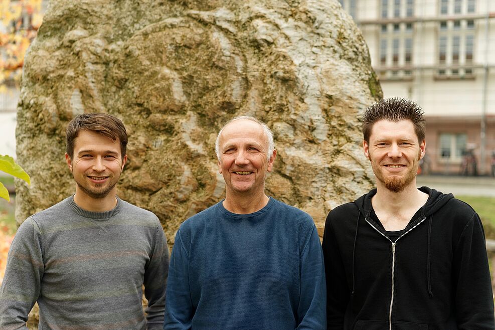 
	the three men who are J-Team smiling at the camera
