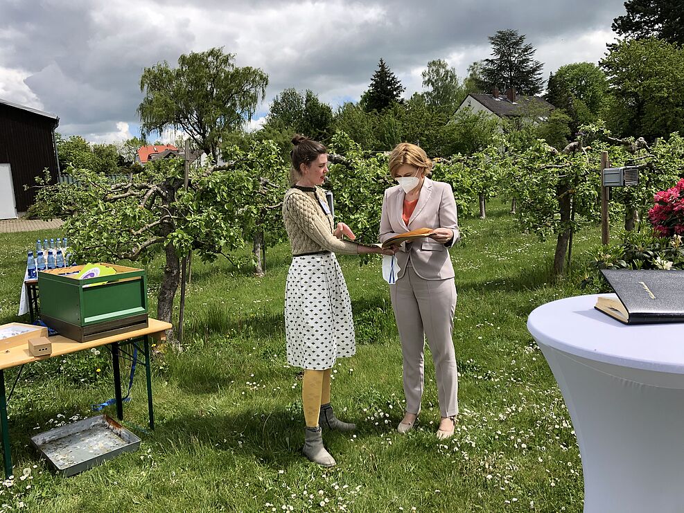 
	Dorothee Lüken zeigt  Frau Klöckner historische Aufzeichnungen eines Imkers. Sie stellte ihre Arbeit im MonVia-Projekt vor. © S.Hahn/JKI
