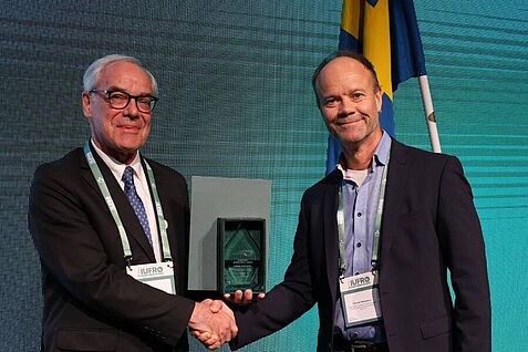 IUFRO-Präsident John Parrotta überreichte die Auszeichnung an Henrik Hartmann (rechts).