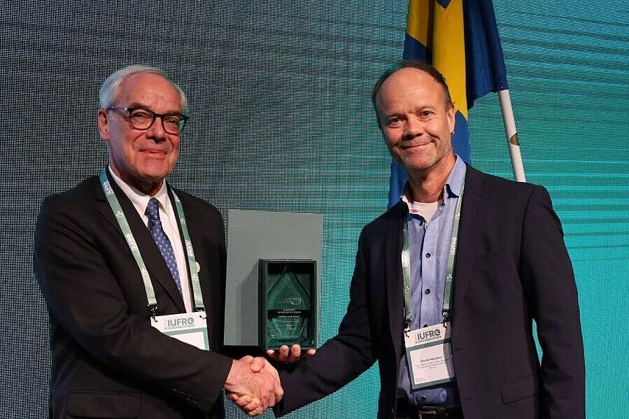 
	IUFRO-Präsident John Parrotta überreichte die Auszeichnung an Henrik Hartmann (rechts).
